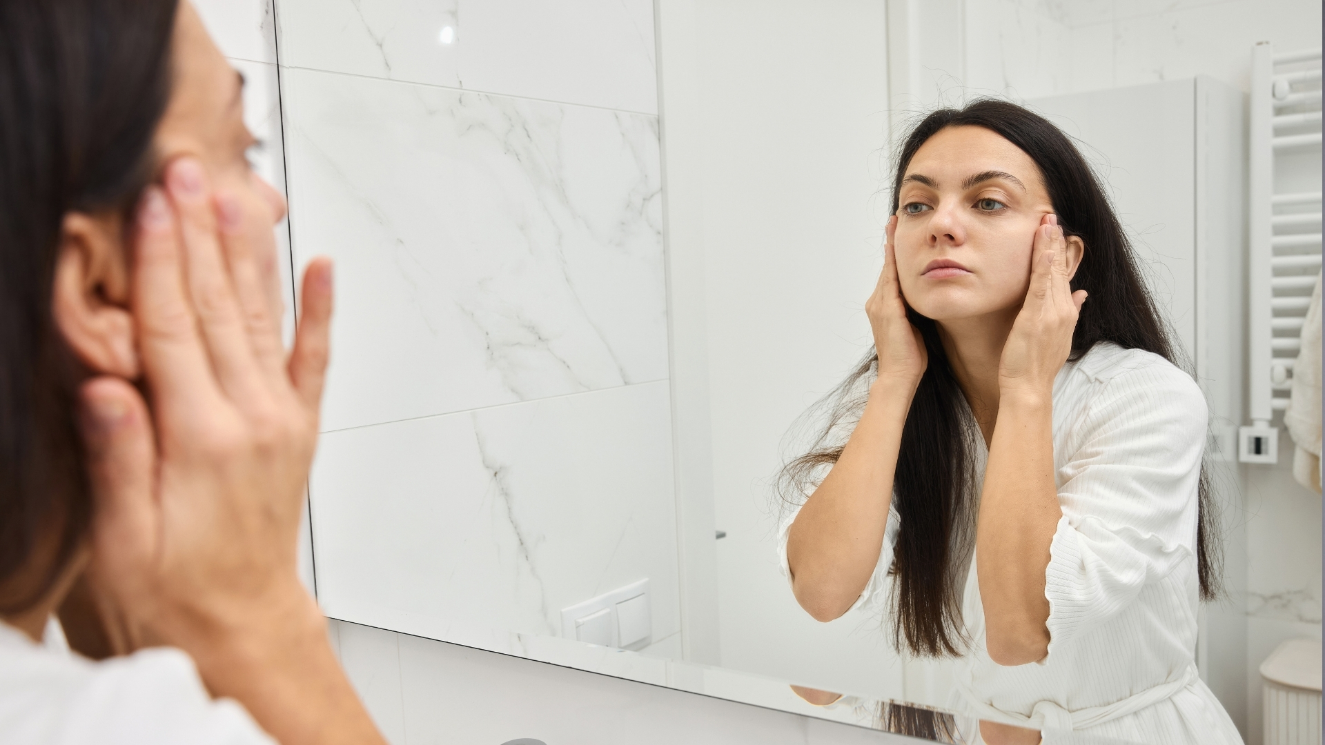 Woman applying cream to face during skincare routine